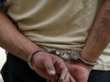 تصویری از یک مجرم دستبند به دست